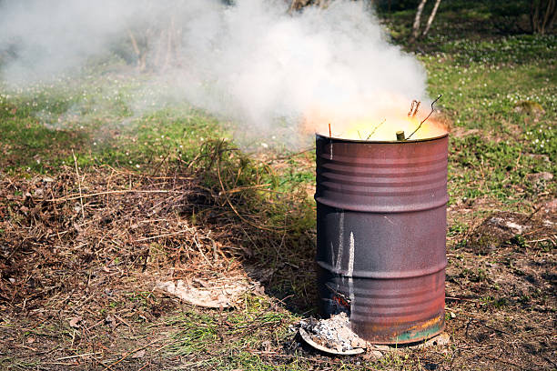 A relevant stock photo of burning barrels in a typical setting.
