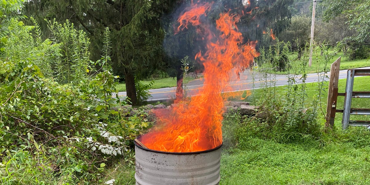 A relevant stock photo of burning barrels in a typical setting.