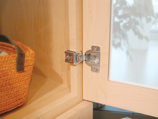 A relevant stock photo of concealed cabinet hinges in a typical setting.