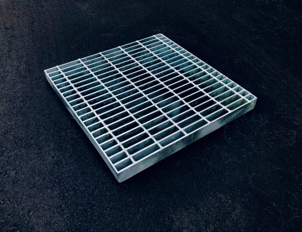 A relevant stock photo of metal grate in a typical setting.