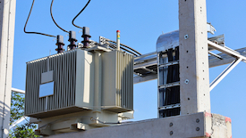 A relevant stock photo of three phase transformer in a typical setting.